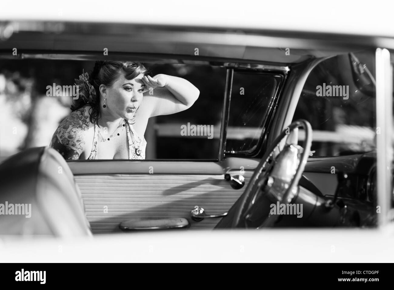 Cute pinup model looking en voiture classique Banque D'Images