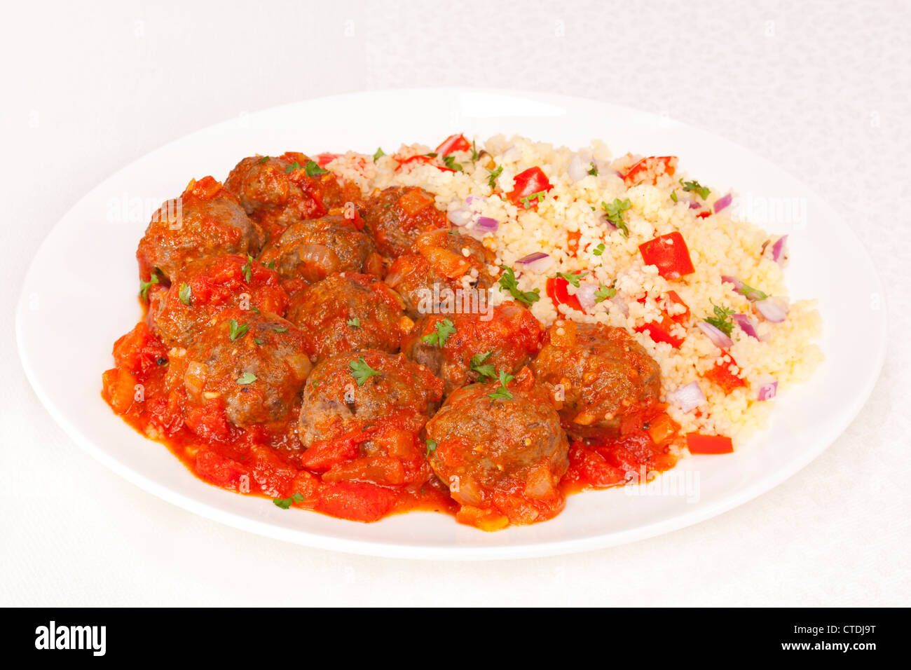Des boulettes de viande en sauce tomate, servi avec du couscous. Banque D'Images
