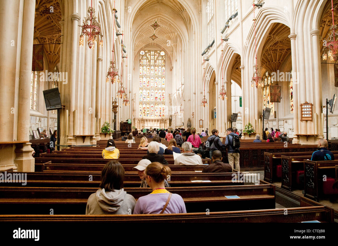 Les visiteurs assis en bancs, l'abbaye de Bath, Somerset, Royaume-Uni scène d'intérieur Banque D'Images