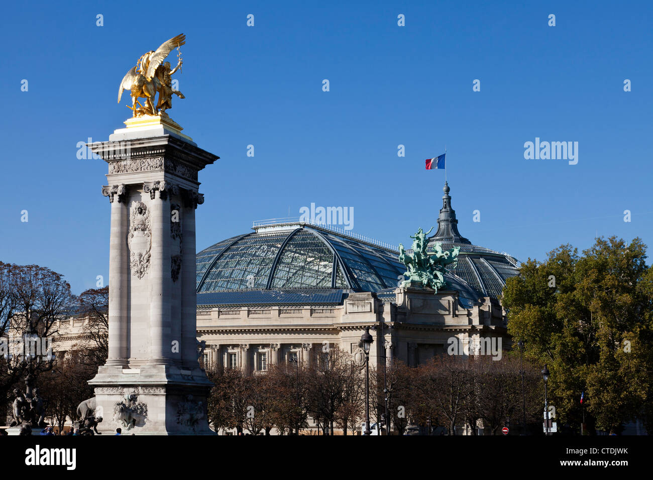 Les magnifiques statues en or que marquer le Pont Alexandre III (pont) avec le Grand Palais des Champs-Elysee en arrière-plan. Banque D'Images