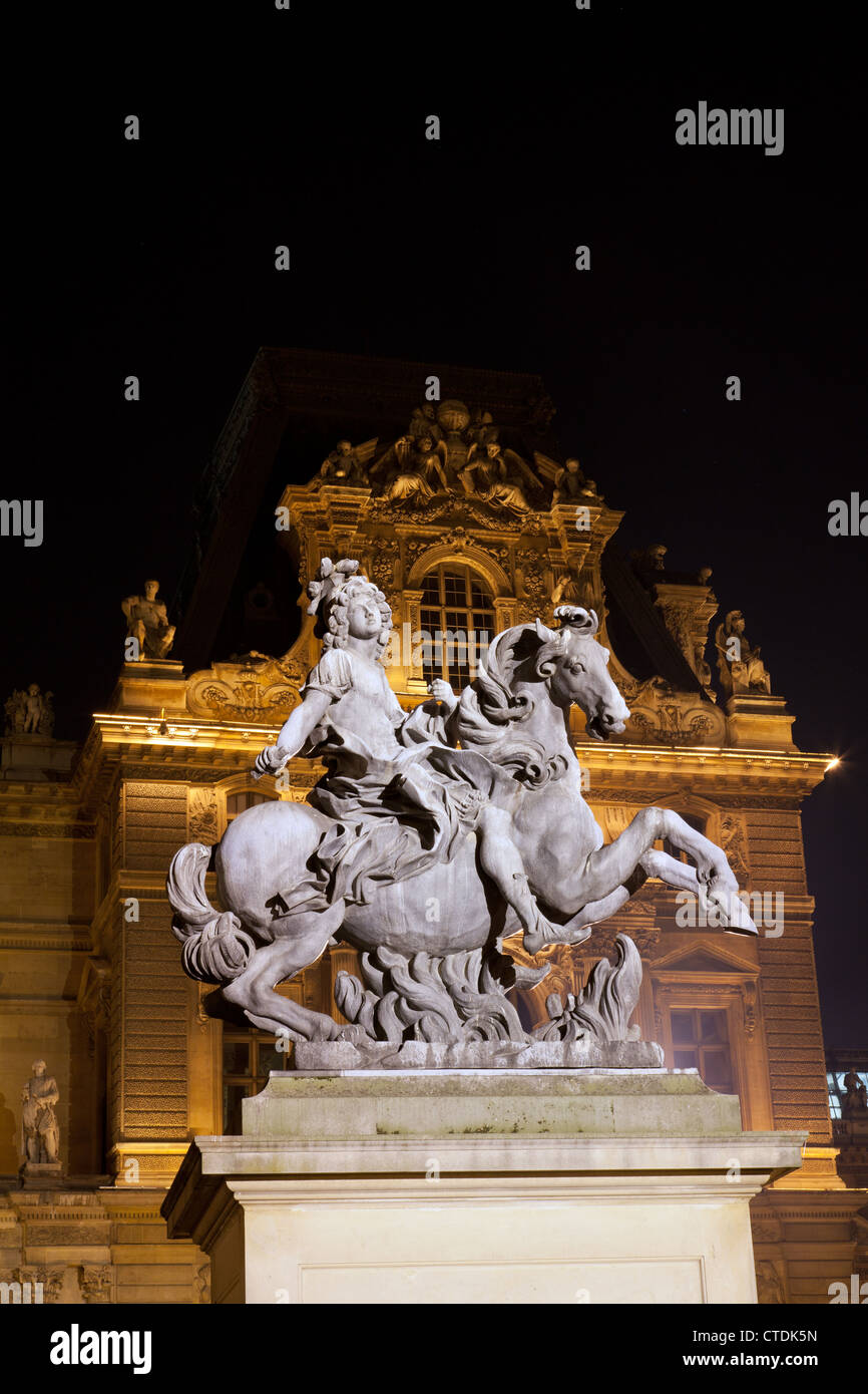 Statue de Louis XIV (Cour Napoléon du Louvre) par Bernini dans la cour du Louvre, illuminé la nuit. Banque D'Images