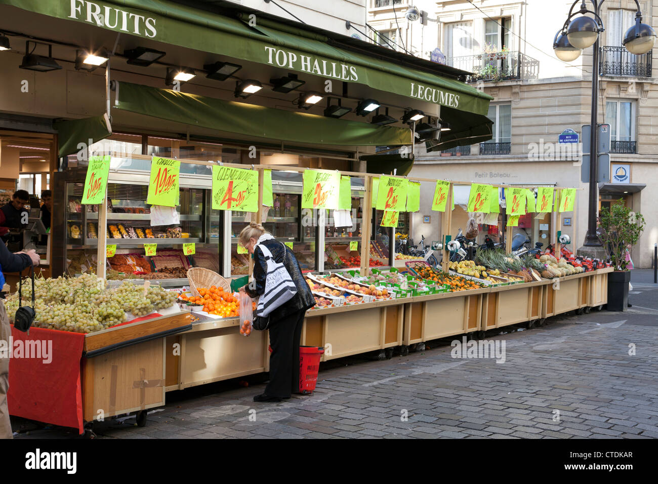 Paris, France : une femme boutiques en haut Halles, un magasin de fruits et légumes sur la Rue Cler. Usage éditorial uniquement. Banque D'Images