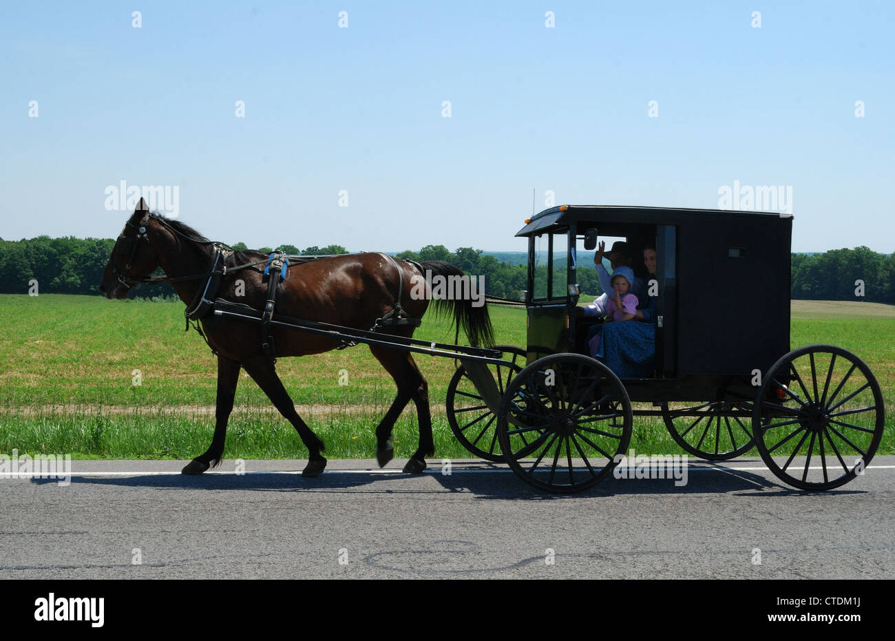 La famille Amish sur la route près de leur ferme. Banque D'Images