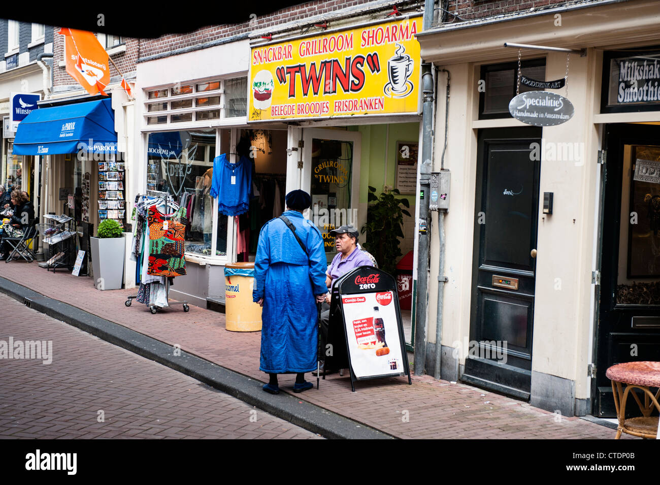 La normale des scènes de rue dans le quartier Jordaan d'Amsterdam. dame en bleu en face de la Snack Grill Room, des jumeaux. Banque D'Images