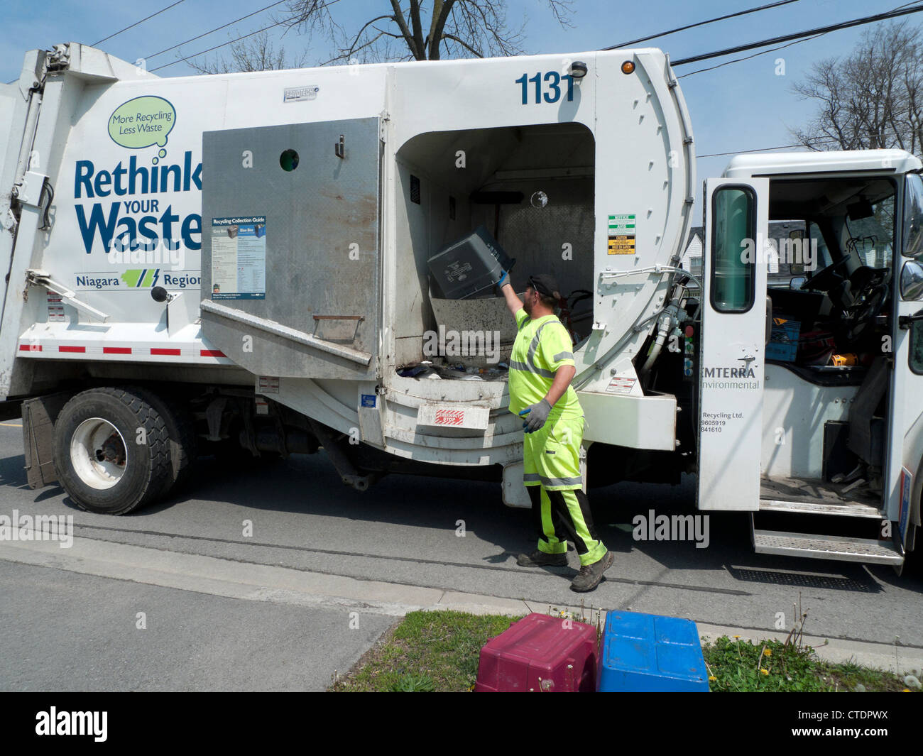 Garbage Man Loading repensez la poubelle de recyclage camion avec du papier recyclé ménager dans la ville canadienne de Fort Erie Ontario Canada Banque D'Images