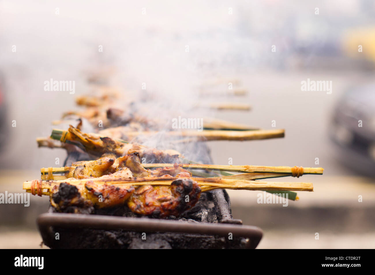 Ayam Percik provient de la côte est de la Malaisie, un poulet mariné, baignant dans une sauce coco épicé et grillé sur charbon de bois. Banque D'Images