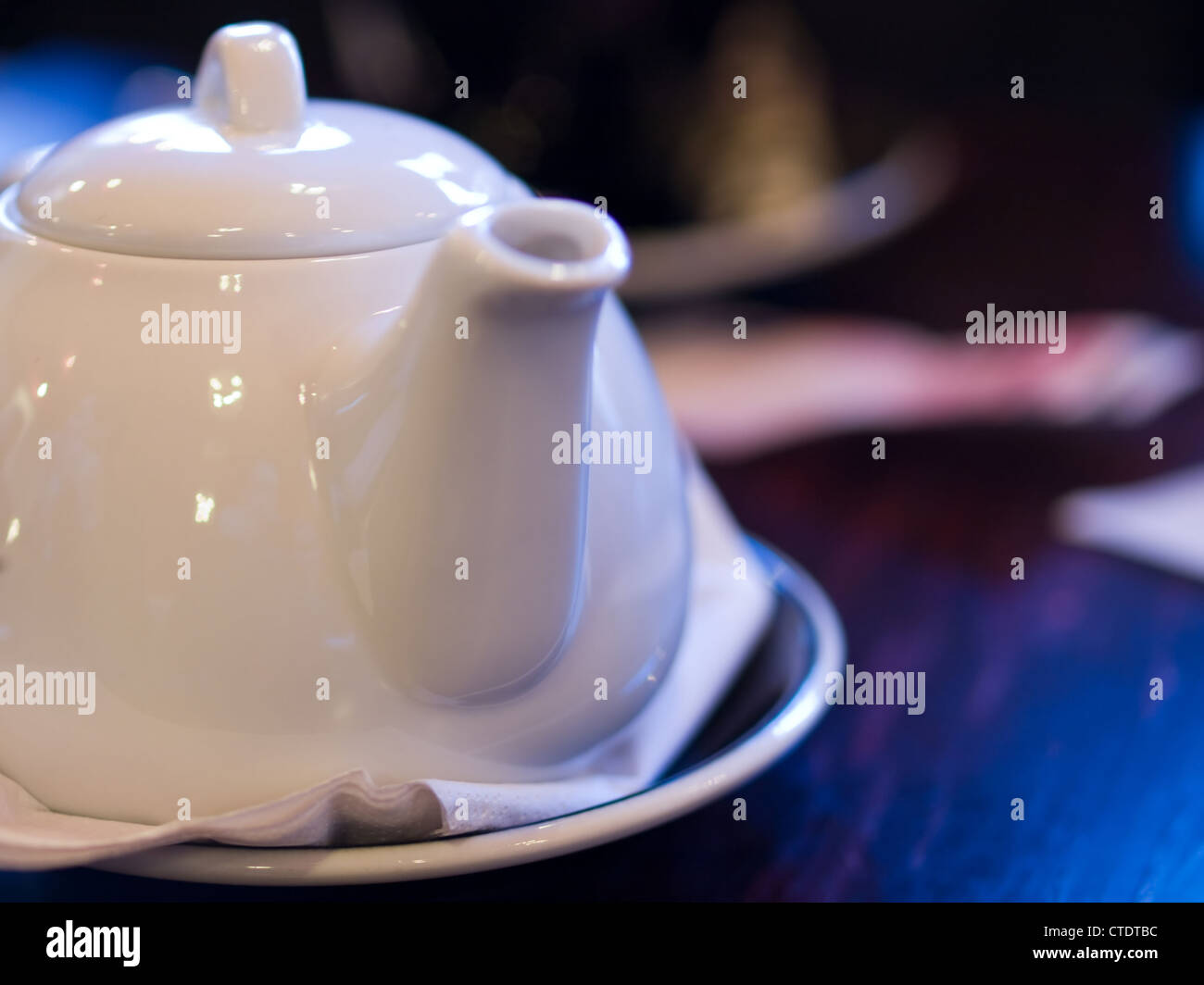 Théière en porcelaine blanche de la vie encore avec une tasse en arrière-plan. Banque D'Images