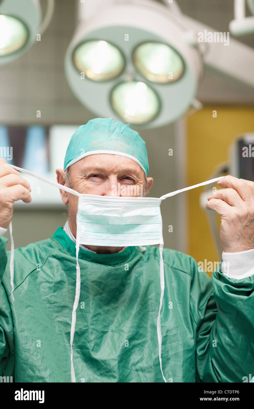 Chirurgien mise sur un masque chirurgical Banque D'Images