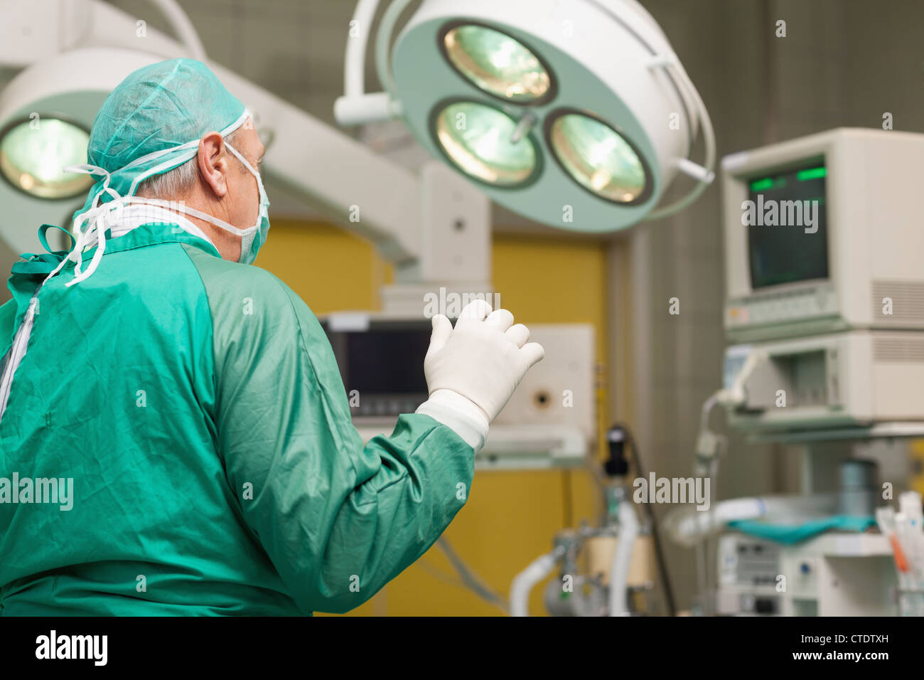 Le port d'équipement de chirurgie chirurgien élever son bras Banque D'Images