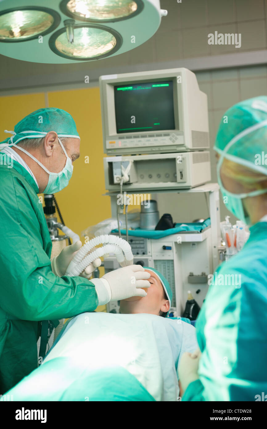 Chirurgien mettre un masque à oxygène sur un patient Banque D'Images