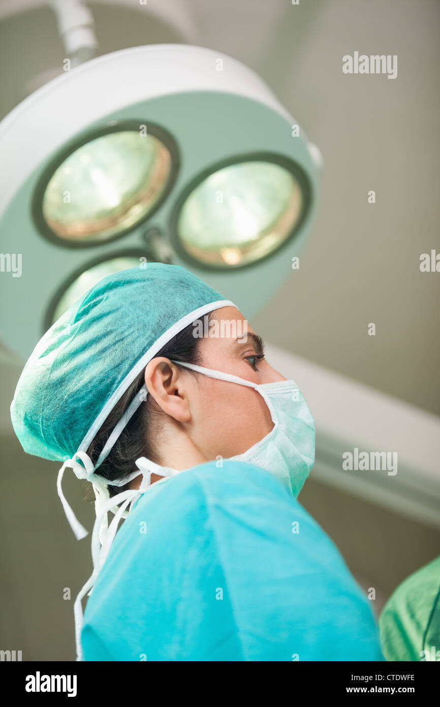 Femme chirurgien sous une lumière chirurgicale Banque D'Images
