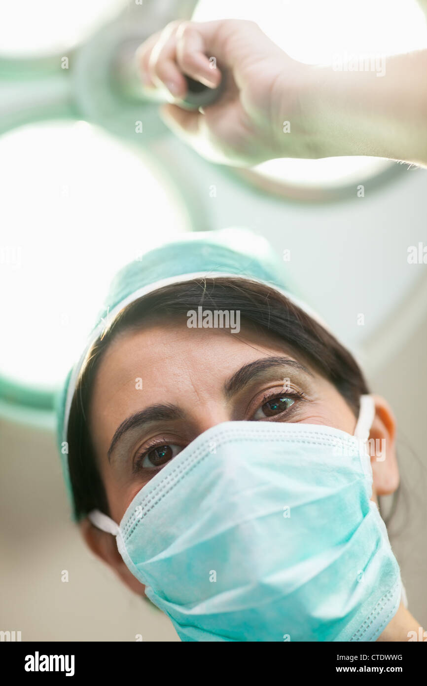 Femme tenant un chirurgien d'éclairage chirurgical Banque D'Images
