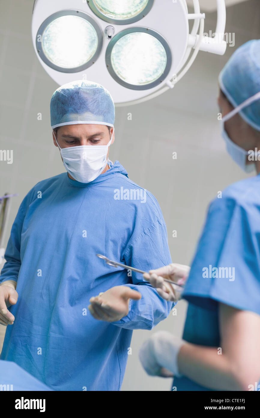 Ciseaux chirurgicaux donnant l'infirmière à un médecin Banque D'Images