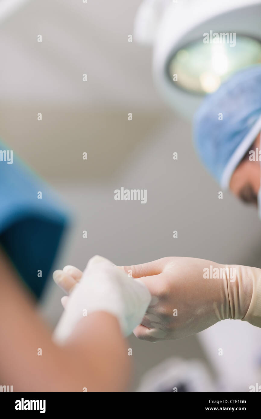 Close up d'une infirmière donnant un ciseaux chirurgicaux à un médecin Banque D'Images
