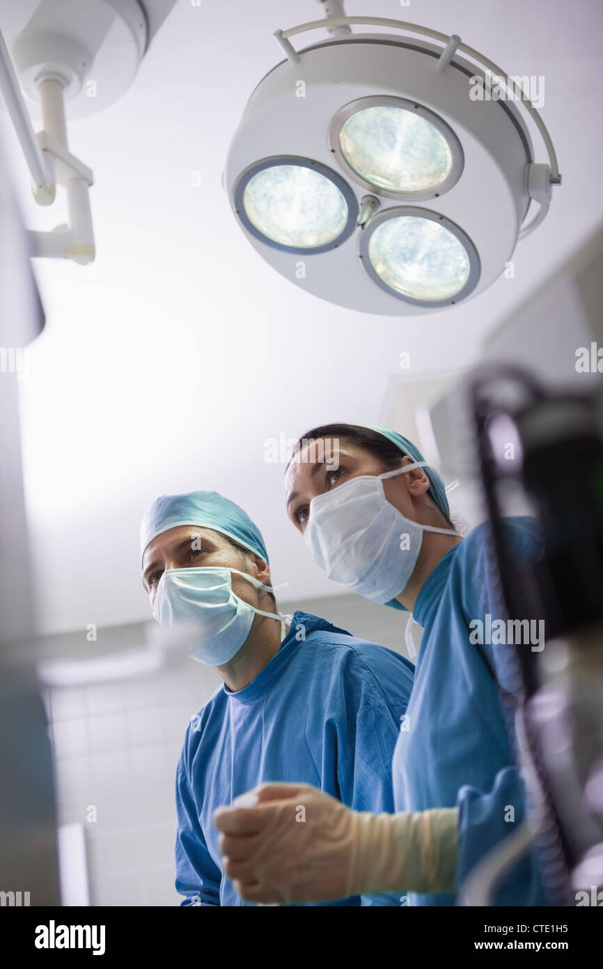 Les médecins à côté de lumière chirurgicale Banque D'Images