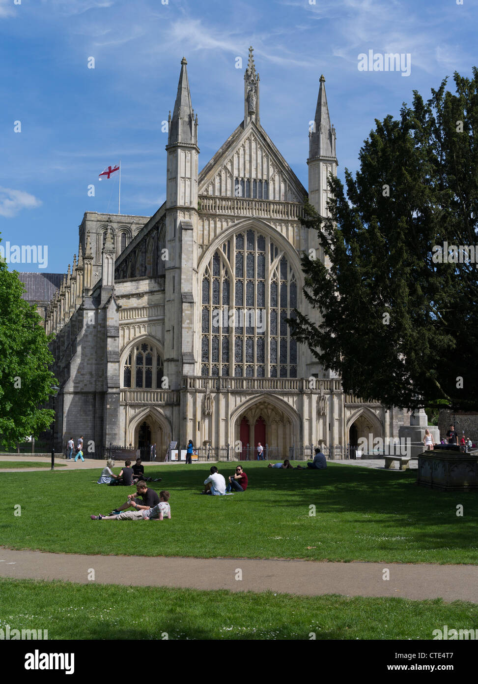 dh Winchester Cathedral WINCHESTER HAMPSHIRE personnes se détendant sur le front de l'herbe de la cathédrale West End Old City Park entrée anglaise minster abbaye du royaume-uni Banque D'Images