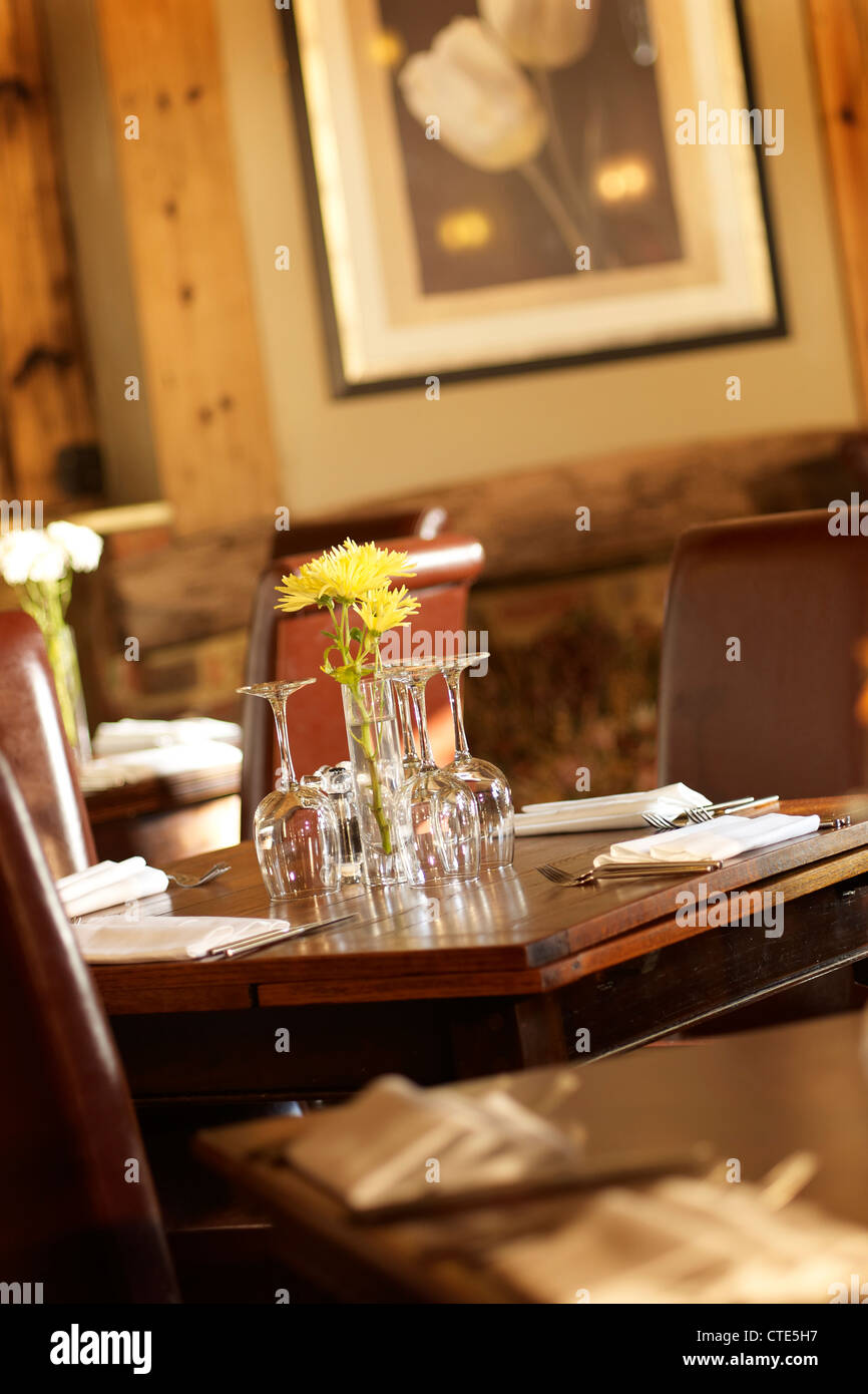 Restaurant La table, montrant des fauteuils de cuir , lunettes et fleurs Banque D'Images