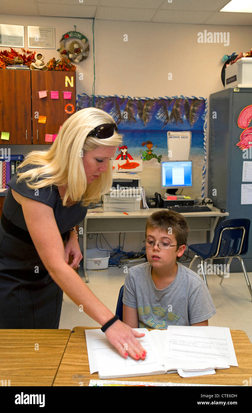 Institutrice aidant les élèves dans une classe de quatrième année à une école primaire publique à Brandon, Florida, USA. Banque D'Images