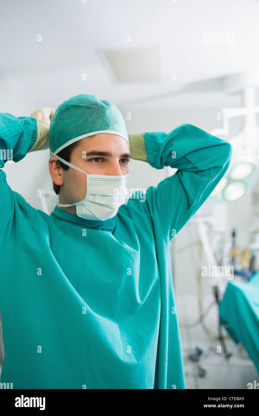 Close up d'un chirurgien fixant son masque Banque D'Images