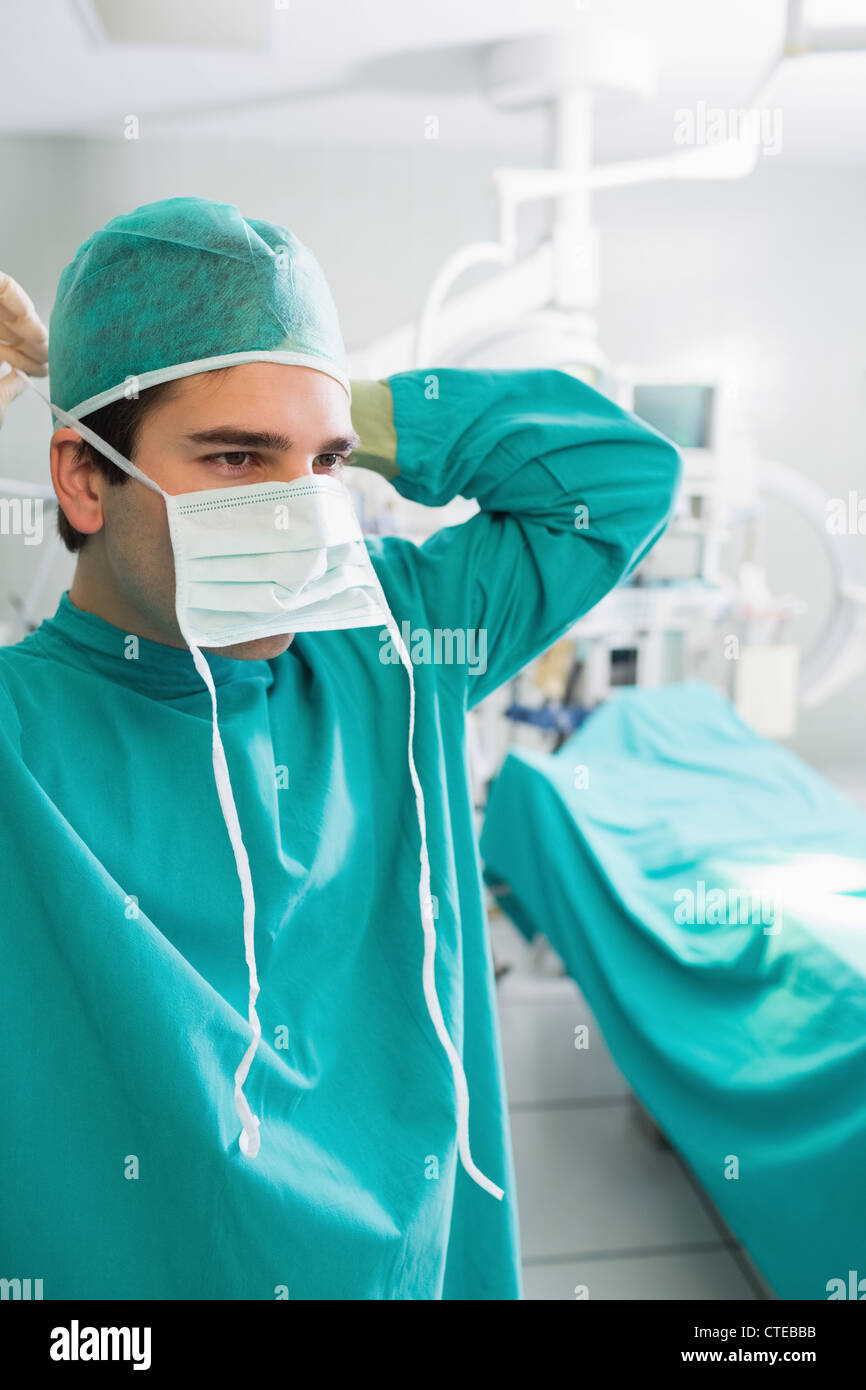 Close up d'un chirurgien de mettre son masque Banque D'Images