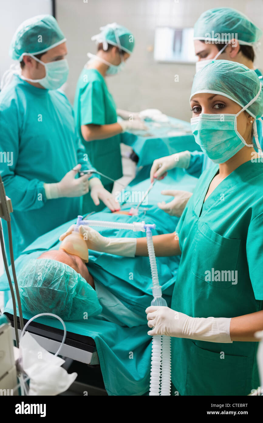 Nurse looking at camera tout en maintenant un masque à oxygène Banque D'Images