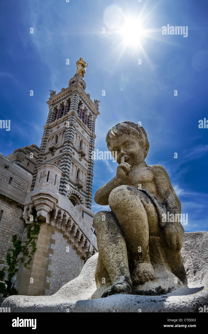 Statue en pierre de silence un peu chérubin appelle à silence. Vue sur le clocher de Notre Dame de la Garde à Marseille Banque D'Images