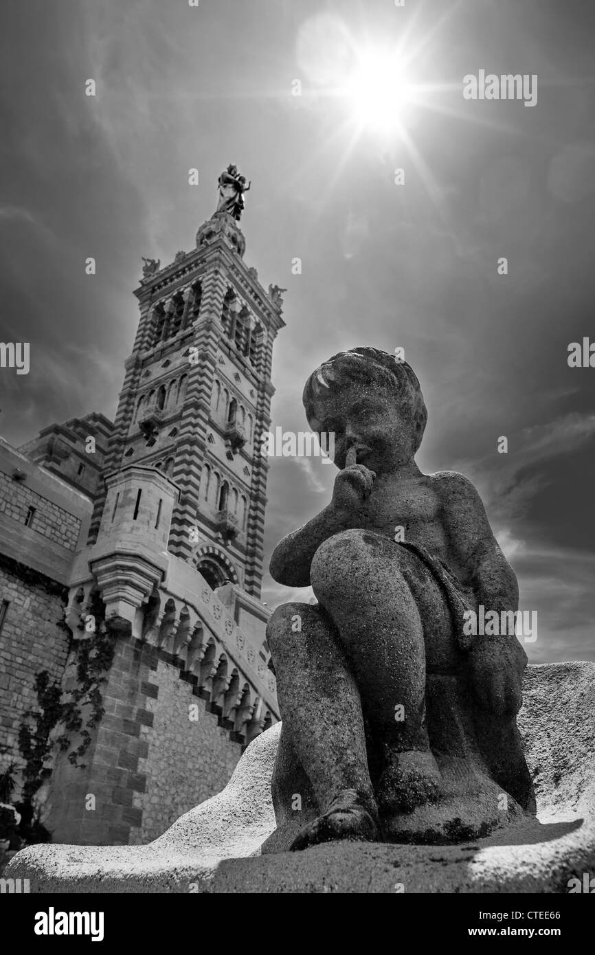 Statue en pierre de silence un peu chérubin appelle à silence. Vue sur le clocher de Notre Dame de la Garde à Marseille. P.c. Banque D'Images
