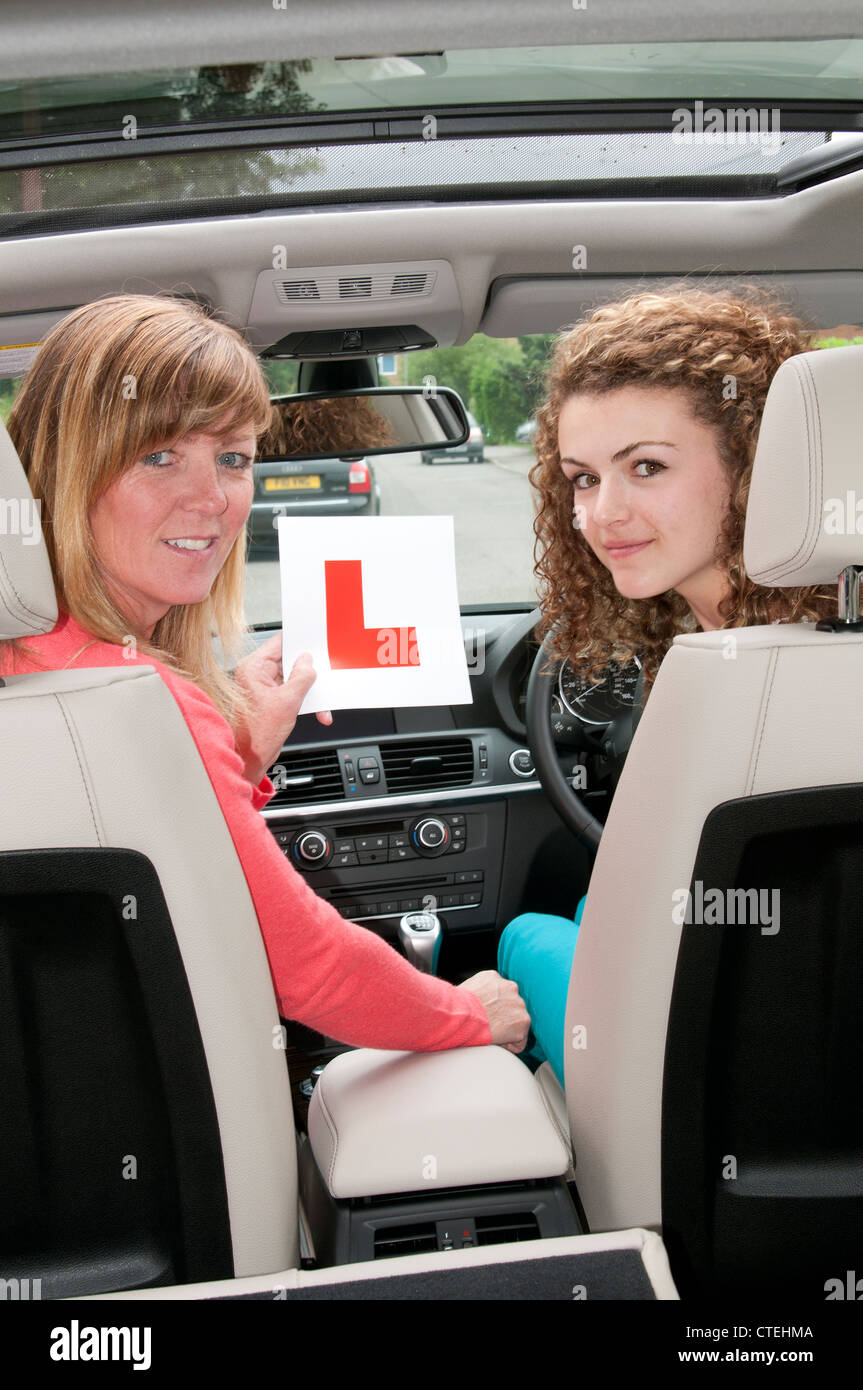 Teenage girl holding L'apprenant avec plaque de test de conduite passe instructeur Banque D'Images