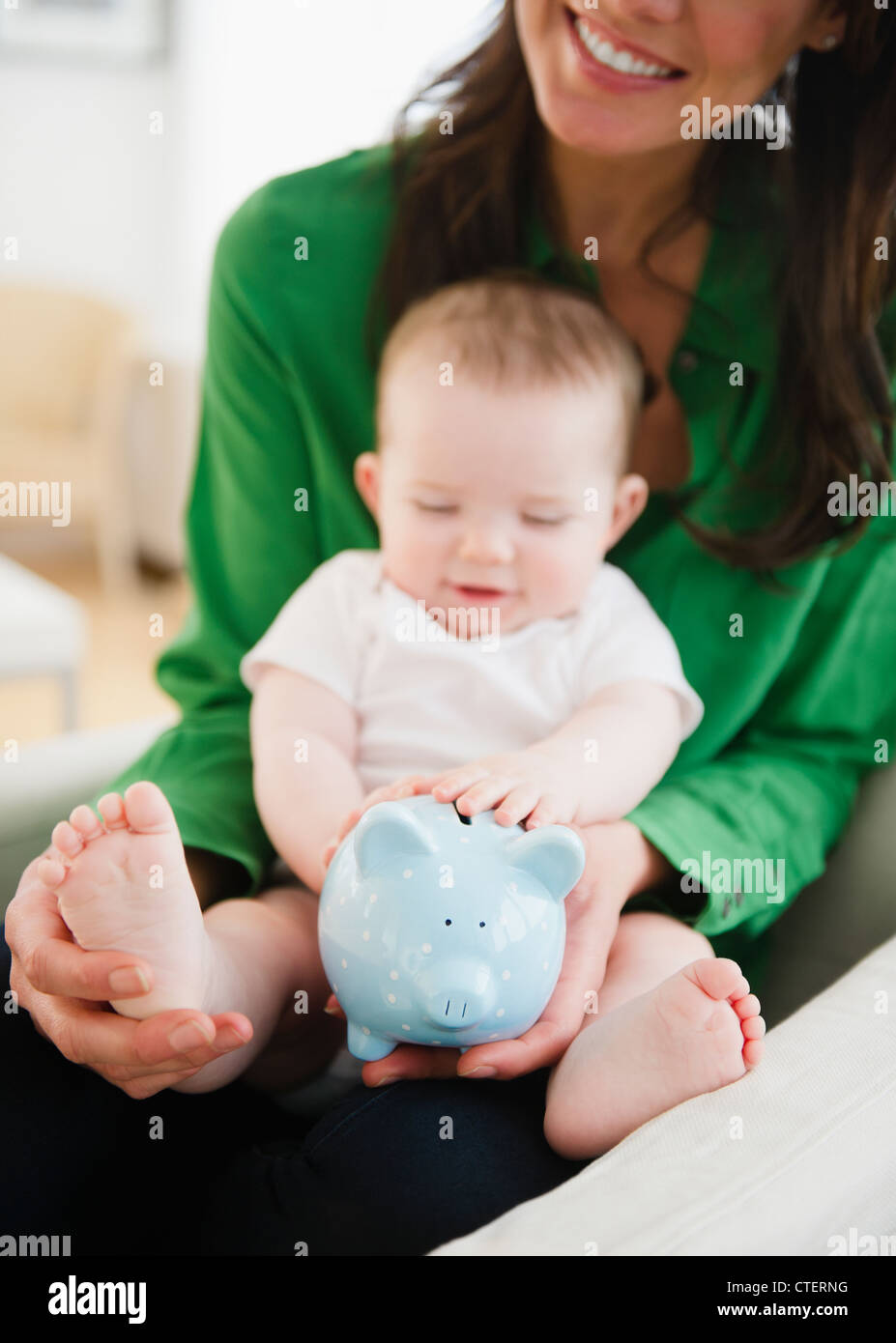 USA, New Jersey, Jersey City, Mother holding Baby Boy (6-11 months) and piggy bank Banque D'Images