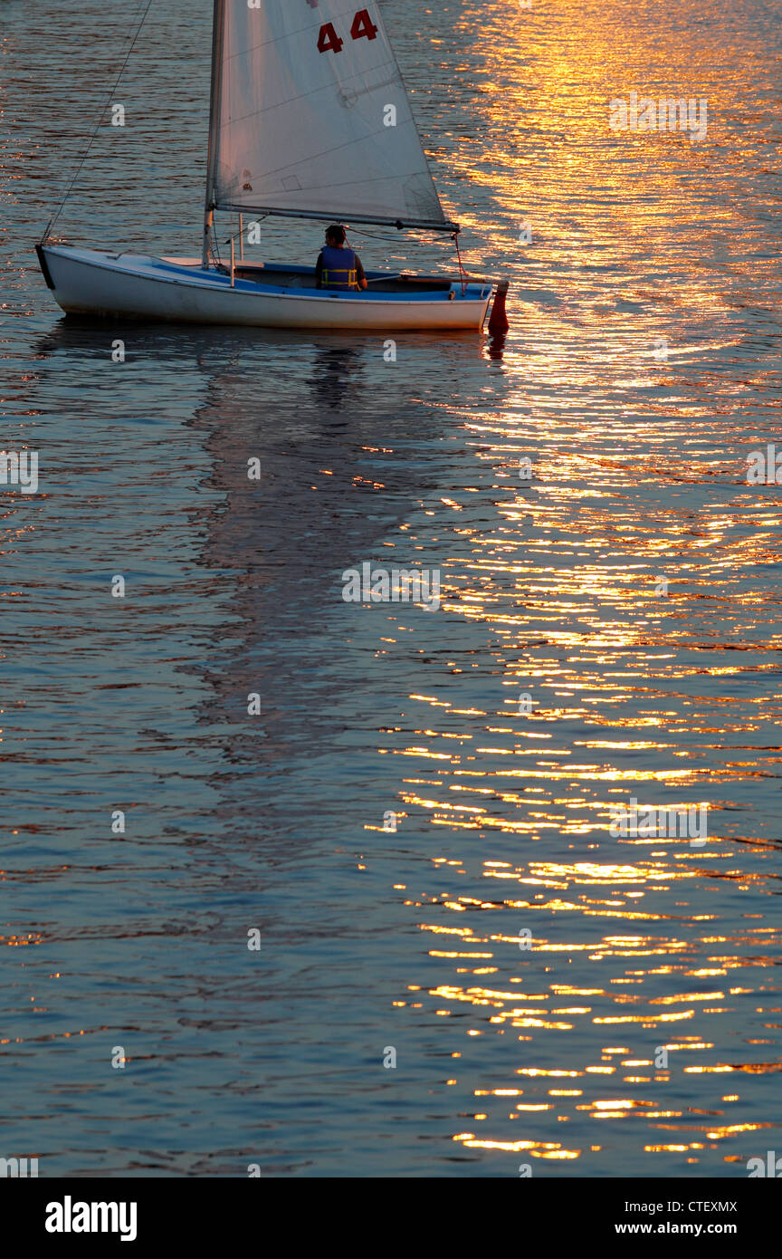 Petit voilier sur la Charles River à Boston, au coucher du soleil Banque D'Images