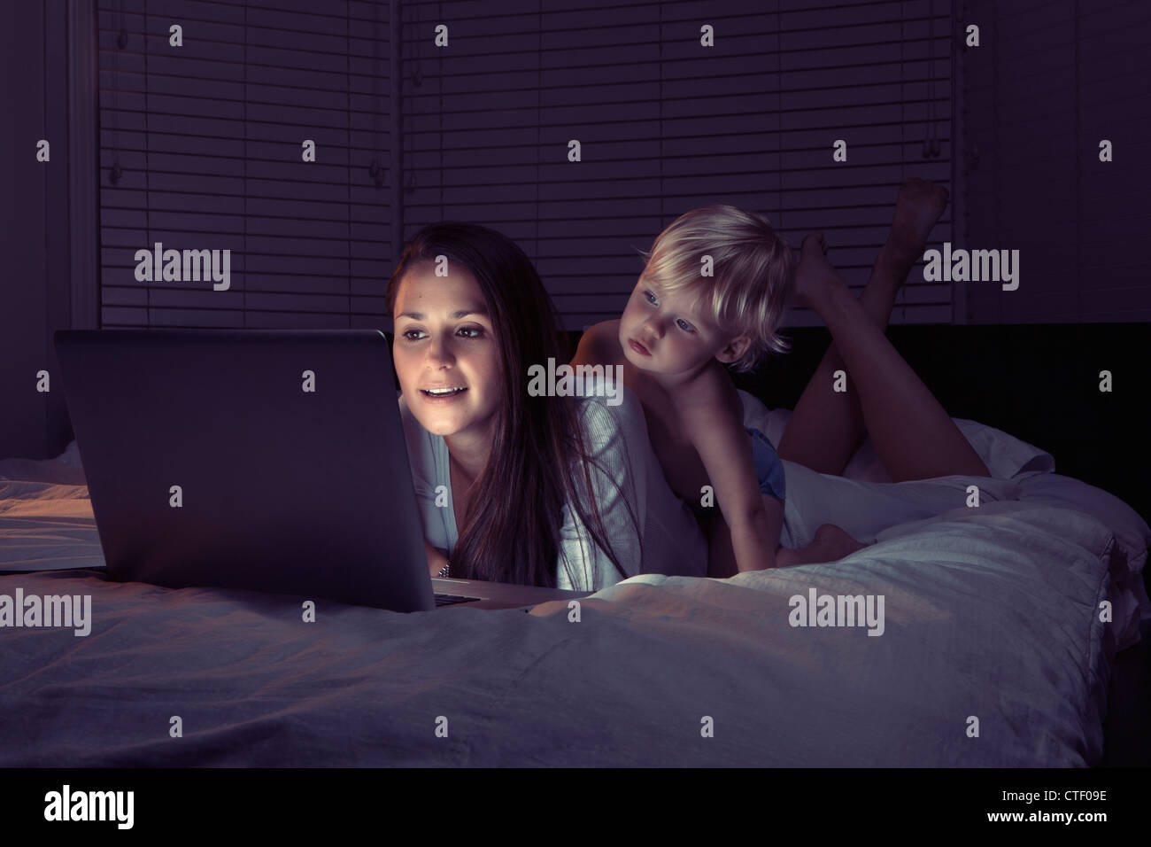 Texas, Austin, Mère avec fils using laptop in bed Banque D'Images