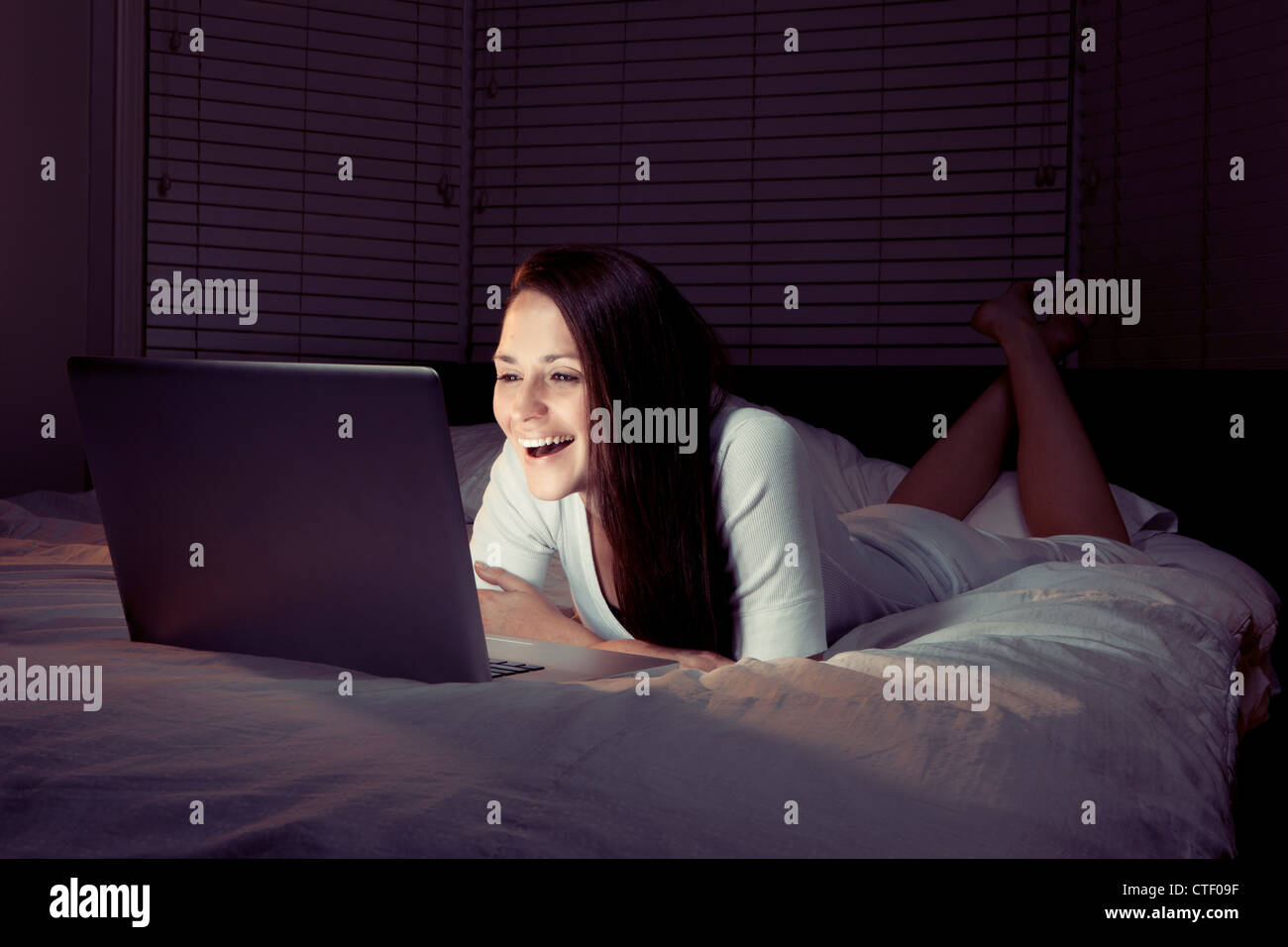 Texas, Austin, Woman using laptop in bed Banque D'Images
