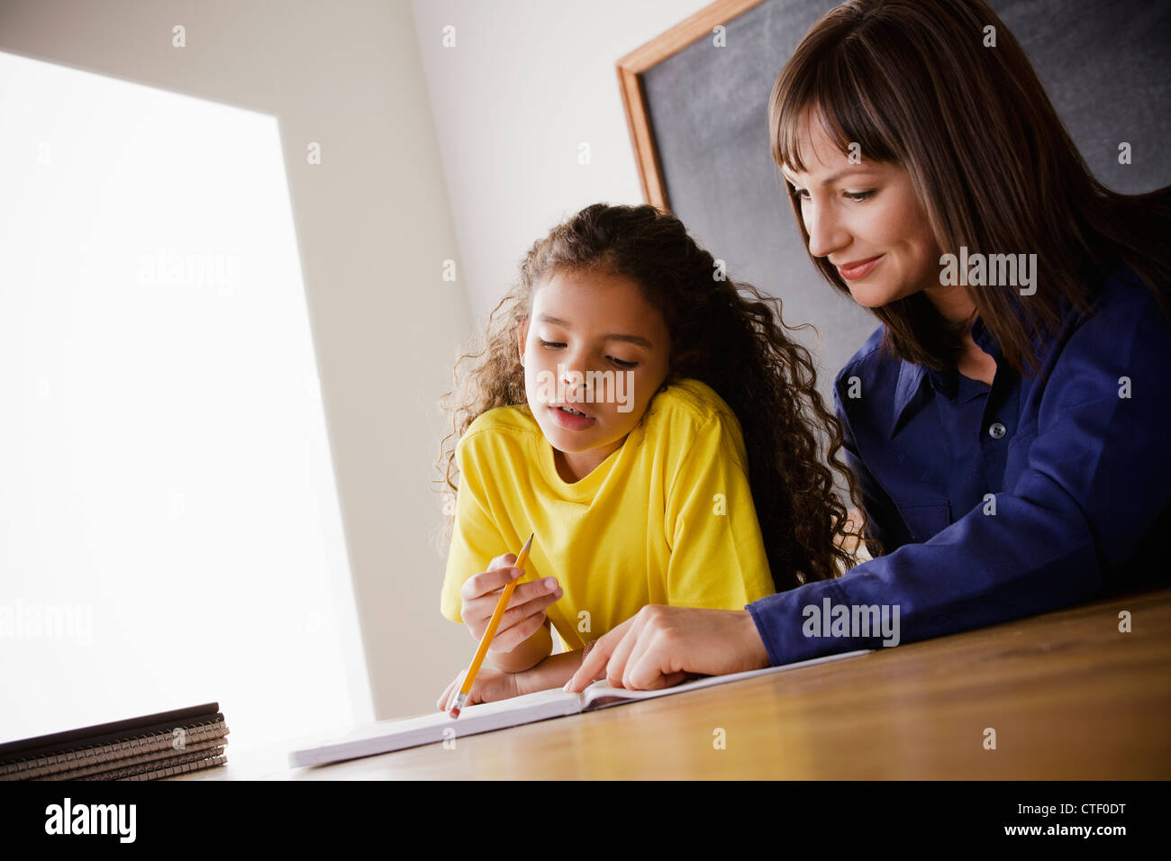 USA, Californie, Los Angeles, lycéenne écrit avec l'enseignant en salle de classe Banque D'Images