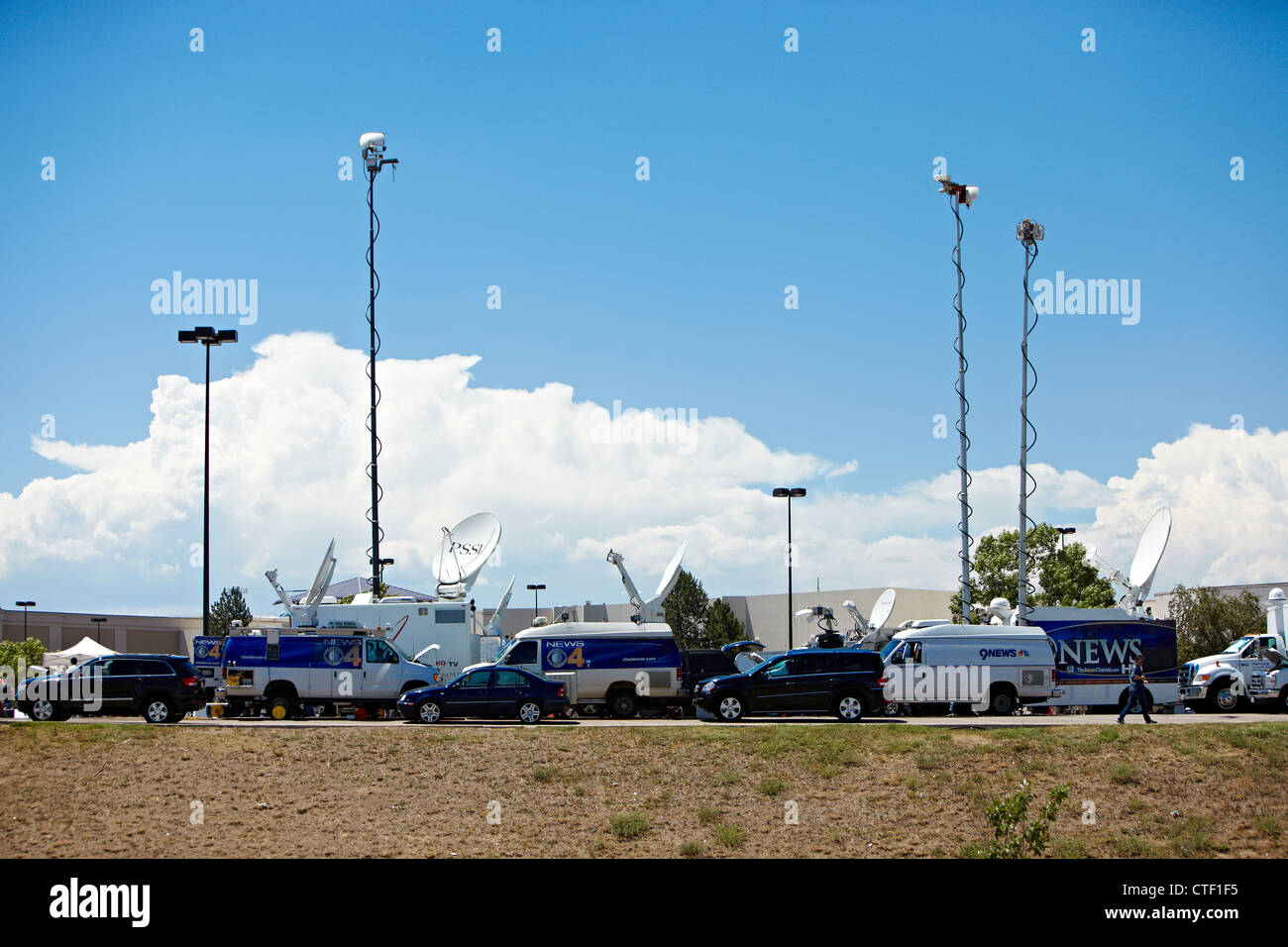 Les stations de nouvelles locales mis en place les véhicules de radiodiffusion près du Colorado cinéma scène de l''Aurora Centre-ville. Banque D'Images