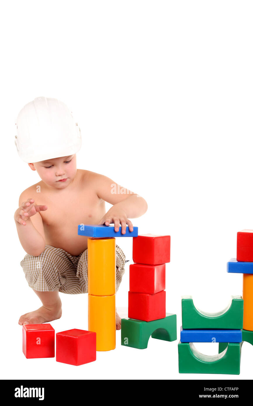 Petit garçon construit une maison de jouets sur le fond blanc Banque D'Images