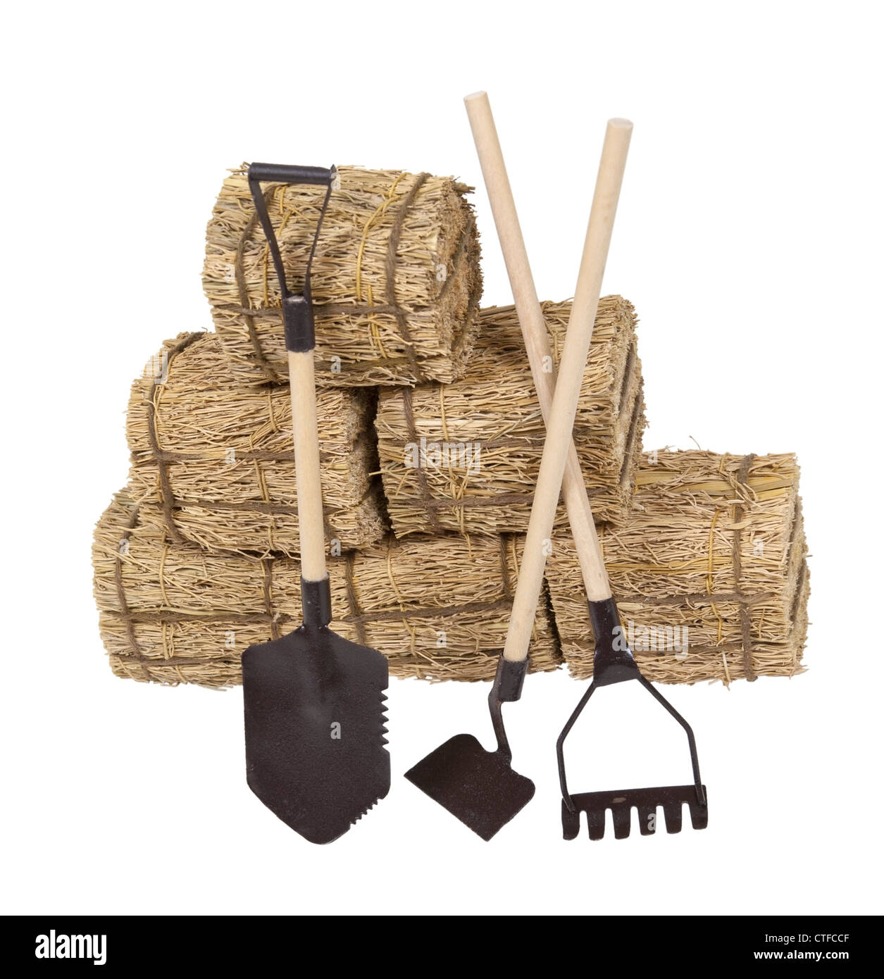 Une variété d'outils de jardin s'appuyant sur une pile de foin - chemin inclus Banque D'Images