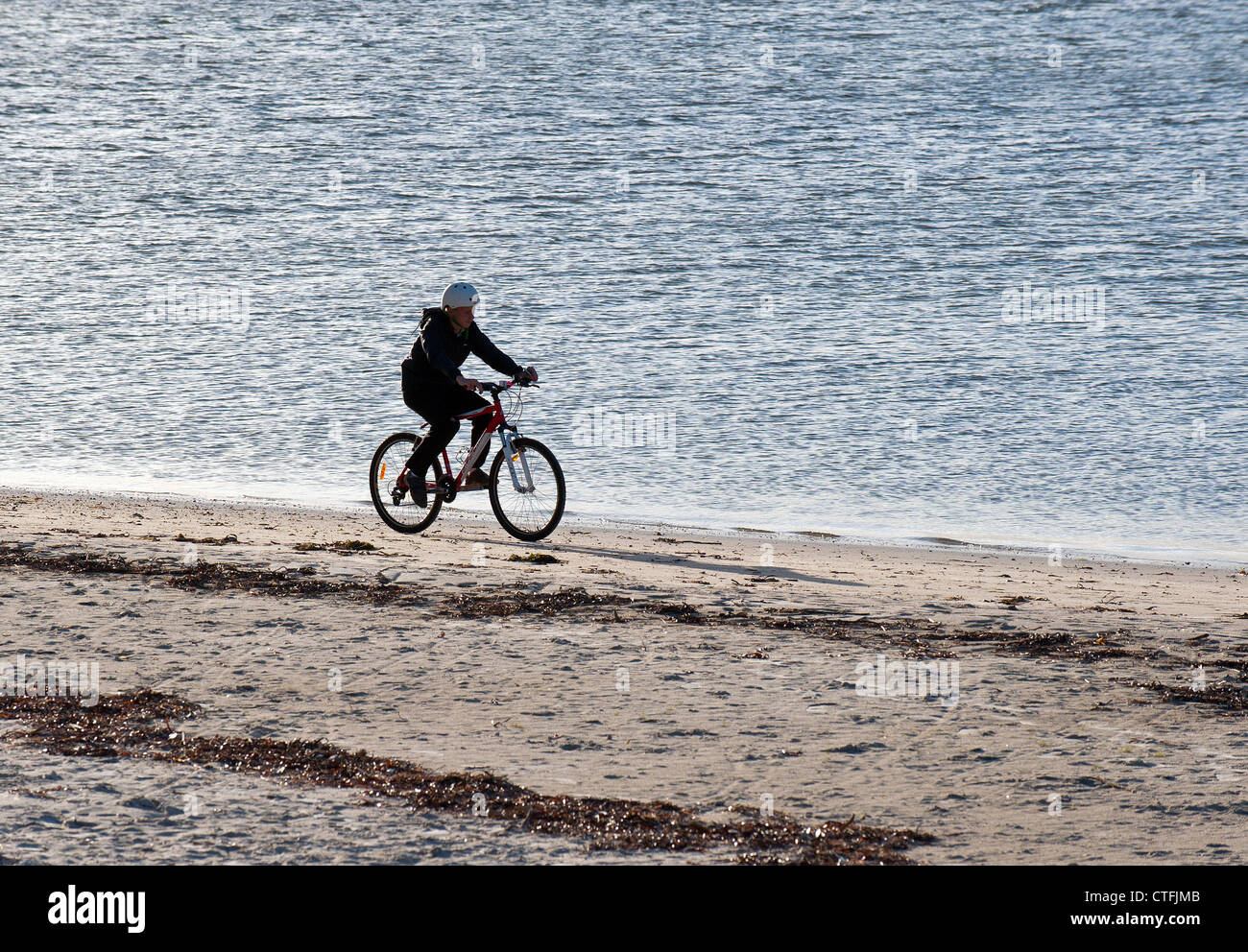 Un cycliste de faire du vélo sur la plage de Middleton à Albany, dans l'ouest de l'Australie Banque D'Images