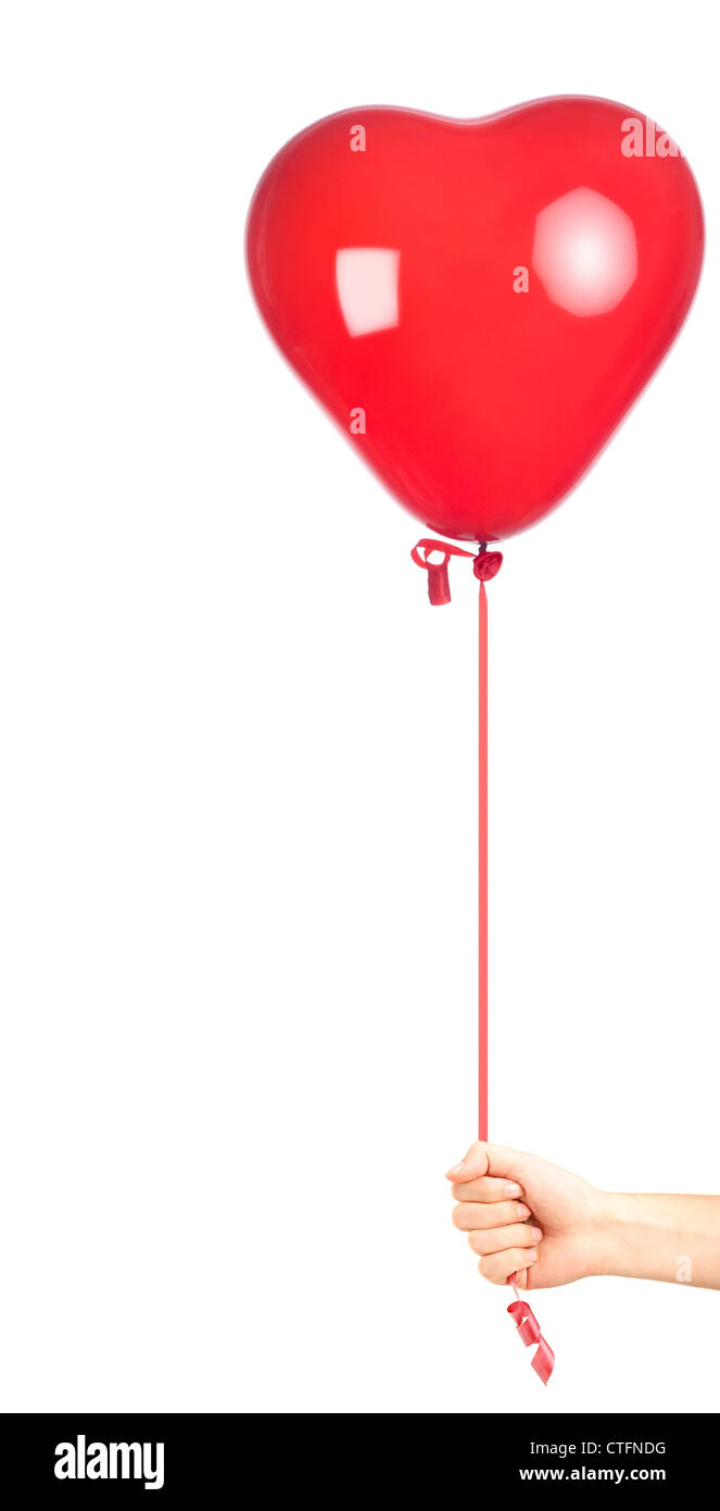 Main tenant un ballon rouge en forme de coeur, isolé sur fond blanc Banque D'Images