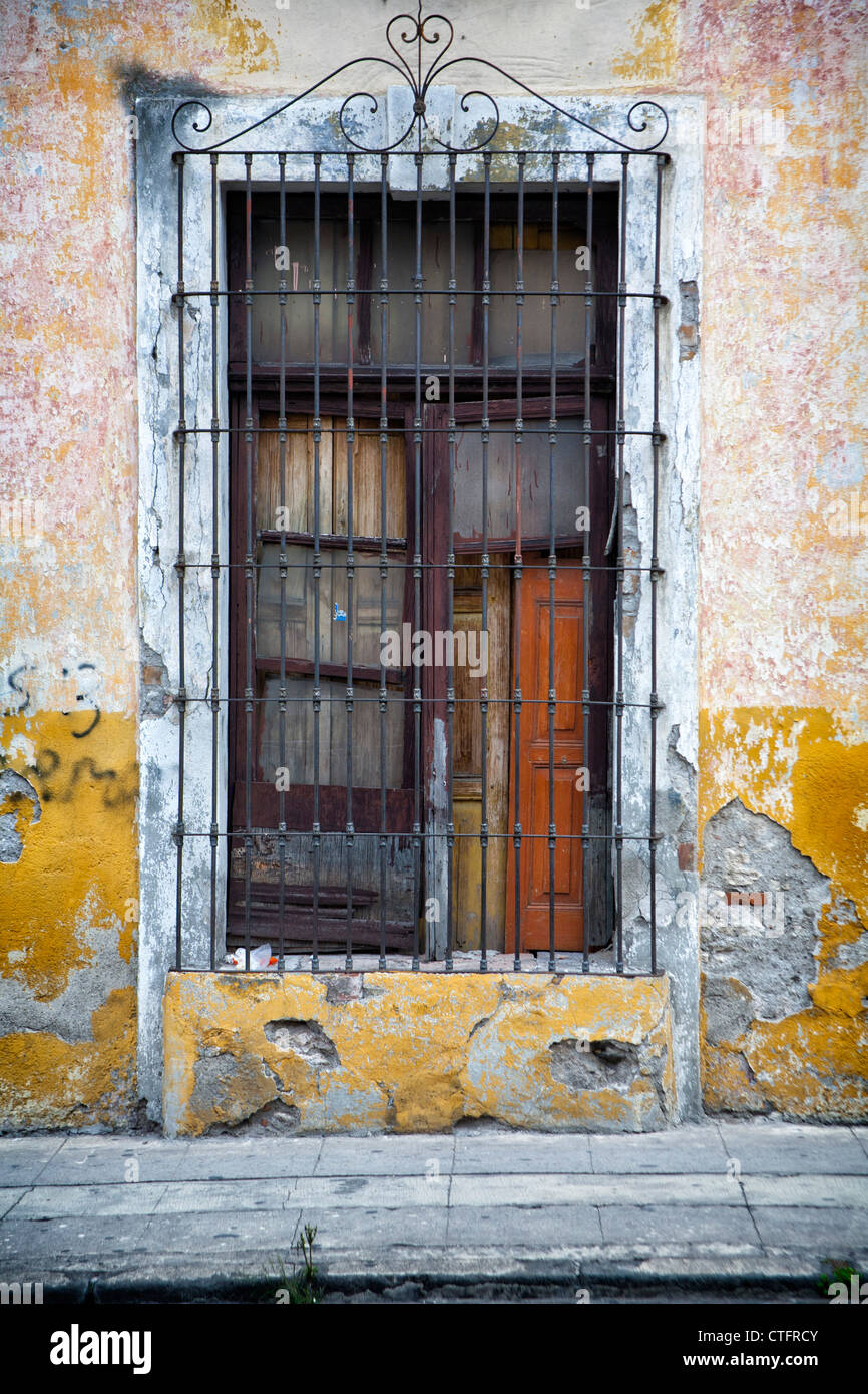 Fenêtre avec volet fermé et grille métallique. Banque D'Images