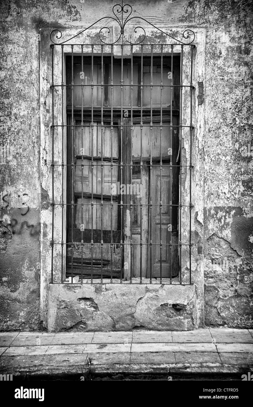 Fenêtre avec volet fermé et grille métallique. Banque D'Images