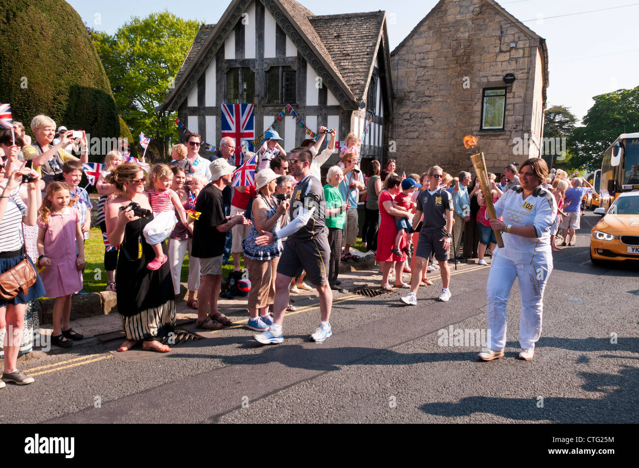 Porteur de Flambeau Olympique foule acclamer, Painswick, Gloucestershire, Royaume-Uni. (23 mai 2012) Banque D'Images