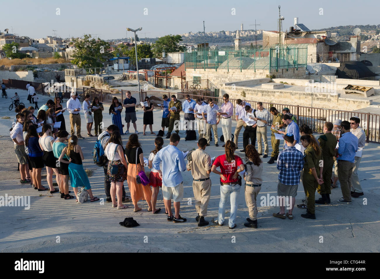 Groupe de jeunes debout dans un cercle d'au coucher du soleil sur un toit. Vieille ville de Jérusalem Israël. Banque D'Images