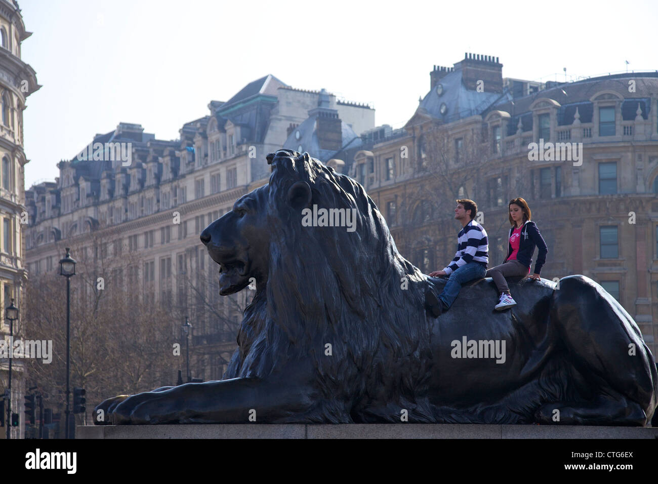 Les jeunes à l'arrière d'un lion de bronze statue, Trafagar Square, London, England, UK, Royaume-Uni, Iles britanniques, GO Banque D'Images