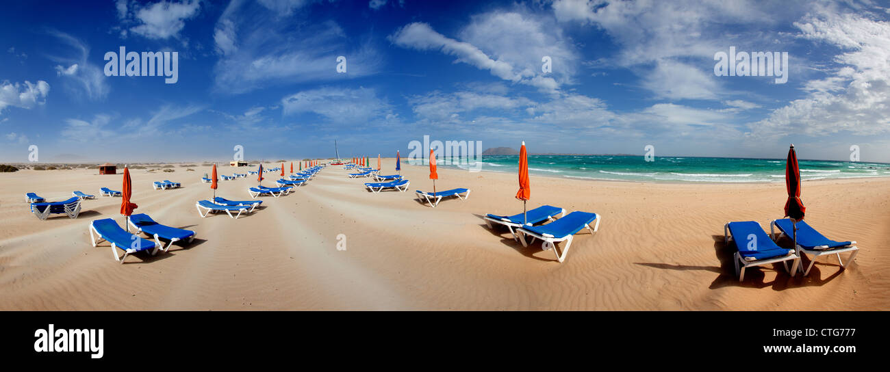 Parasol et transats sur la plage de sable de l'île de Fuerteventura, Espagne Banque D'Images