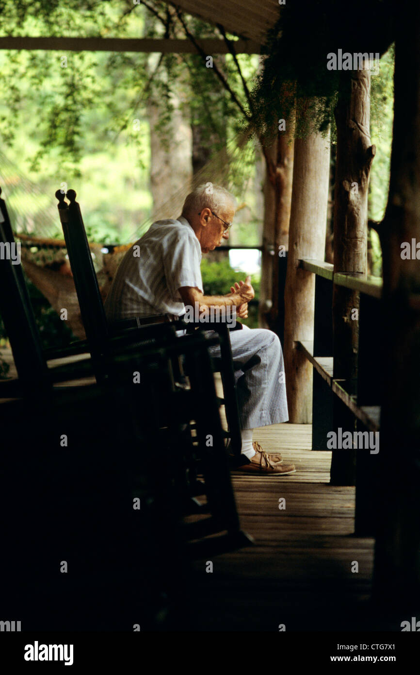 1980 PERSONNES ÂGÉES SENIOR MAN SITTING ON PORCH EN FAUTEUIL À BASCULE Banque D'Images