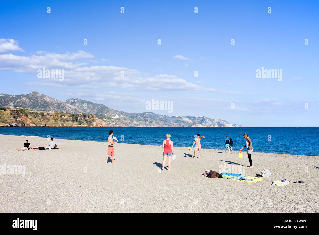 Groupe d'adolescents s'amusant sur une plage au bord de la mer Méditerranée à Nerja, Costa del Sol, Espagne. Banque D'Images