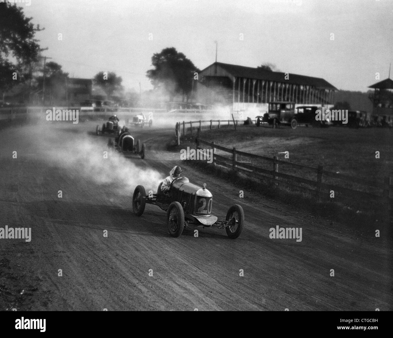 1930 COURSE AUTOMOBILE SUR UN CHEMIN DE TERRE AVEC DES VOITURES TOURNER AUTOUR DES COUPS DE LA POUSSIÈRE Banque D'Images