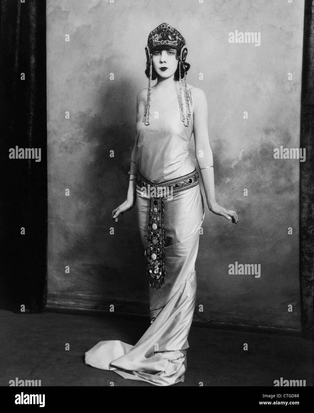 Années 1920 FEMME PORTANT ÉGYPTIEN EXOTIQUE INSPIRÉ ROBE boiteux avec costume cravate CEINTURE BIJOUX FASHION Banque D'Images