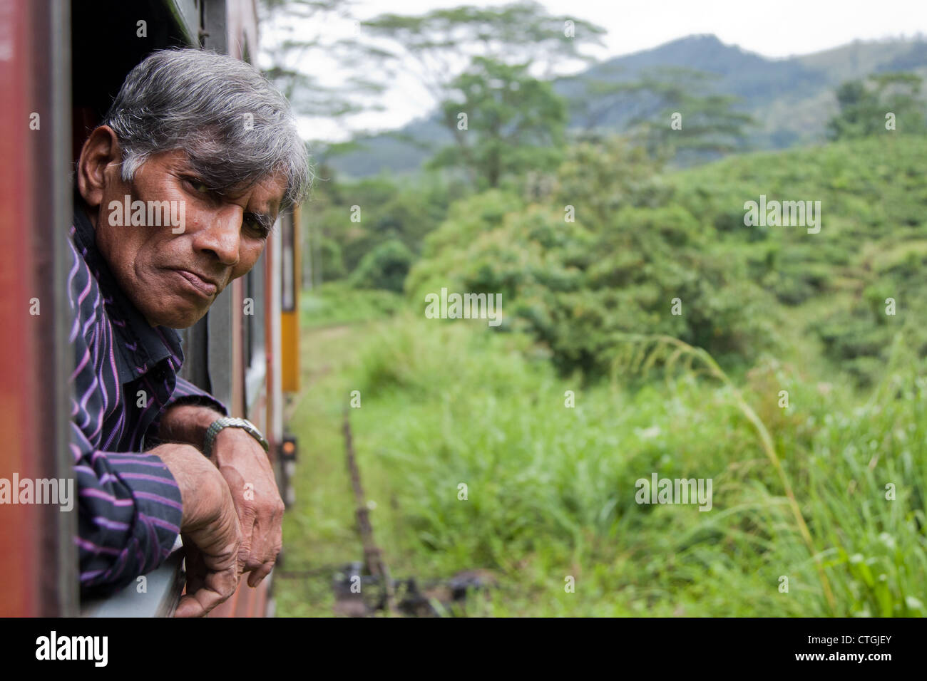 Vieil homme se penchant hors de la fenêtre du train au Sri Lanka Banque D'Images