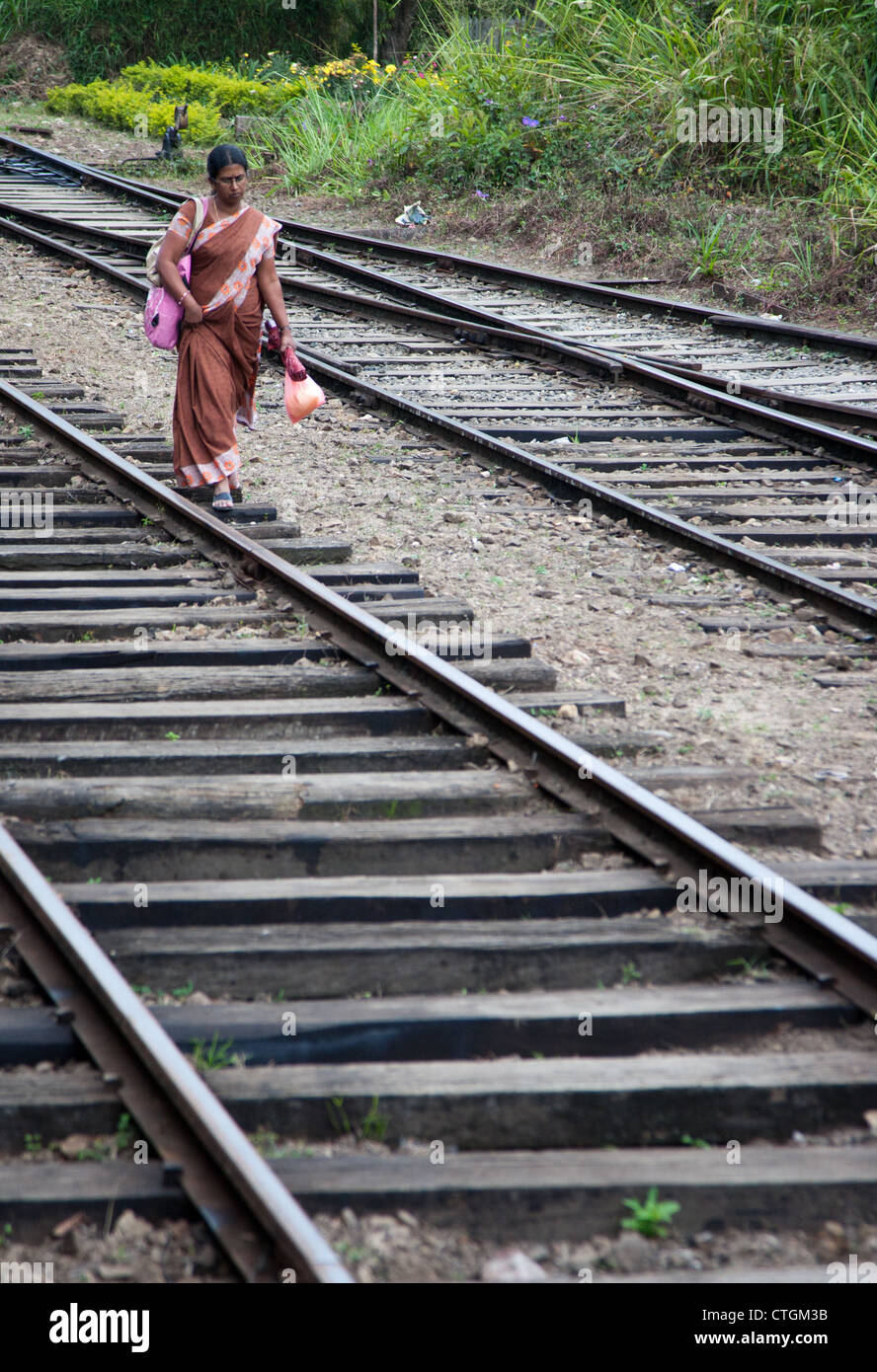 Une femme se promène le long de la voie ferrée, le train au Sri Lanka. Banque D'Images